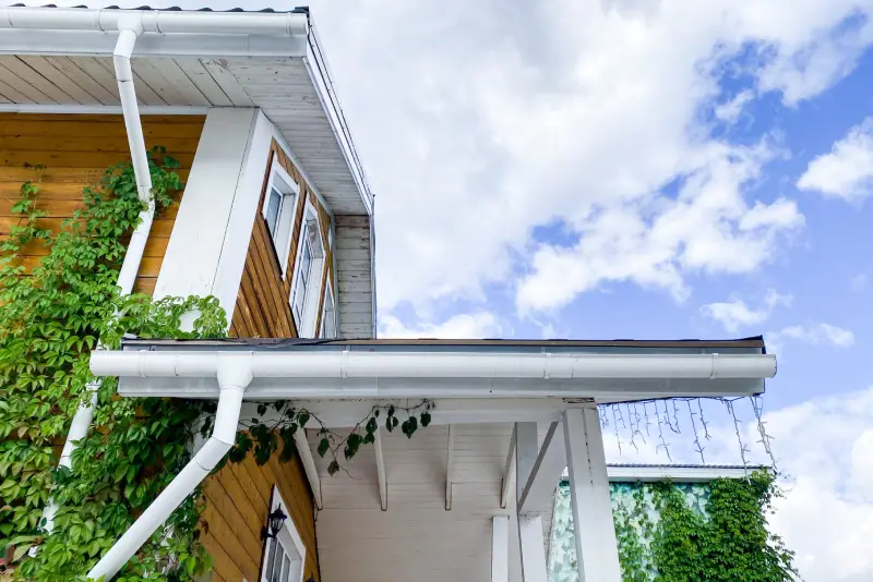 A charming, picturesque house with a lovely, inviting porch stands proudly against a clear blue sky, creating a delightful and enchanting atmosphere that captivates everyone who happens to see it